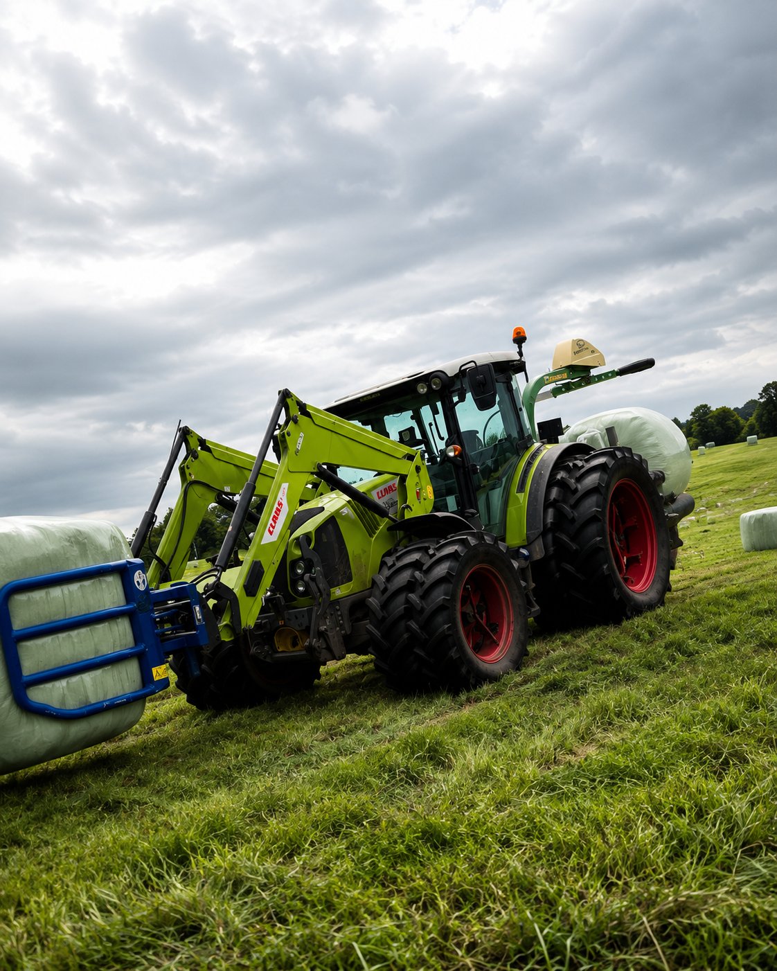 CLAAS Arion mit Frontlader trägt einen gewickelten Silageballen